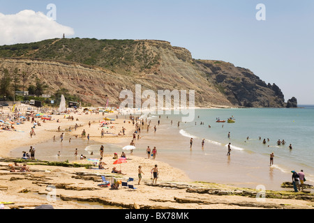 Le persone godono di sole e sabbia dorata a Praia da Luz beach a Lagos, Algarve, Portogallo, Europa Foto Stock