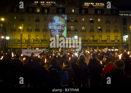 In seguito il 2010 Premio Nobel per la pace cerimonia di premiazione per imprigionato il dissidente cinese Liu Xiaobo, una folla di diverse centinaia di persone hanno marciato in processione portando bandiere e torce, giù principale di Oslo boulevard, Karl Johans Gate, all'hotel dove i vincitori di solito soggiornare durante la loro visita in Norvegia. In Liu di assenza, un ritratto di lui è stato proiettato sulla facciata dell'hotel. La fiaccolata è diventata una parte preziosa del Nobel annuali feste. (Foto di Scott London) Foto Stock