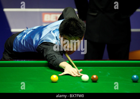 Liang Wenbo della Cina in azione contro Ronnie OSullivan dell Inghilterra, durante il primo round del Betfred World Snooker Champions Foto Stock