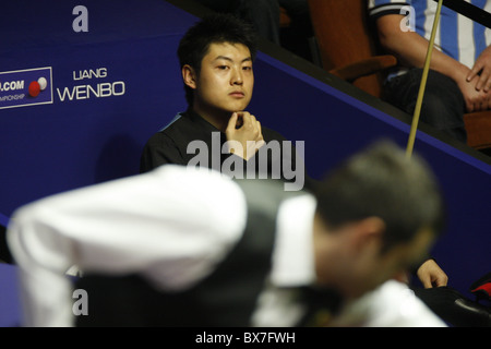 Liang Wenbo della Cina in azione contro Ronnie OSullivan dell Inghilterra, durante il primo round del Betfred World Snooker Championsh Foto Stock