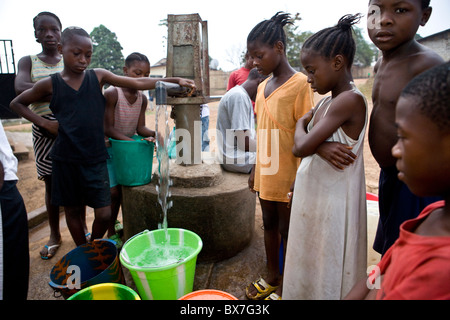 Gli abitanti di un villaggio di pompare acqua da un quartiere ben in Kakata, Libera, Africa occidentale. Foto Stock