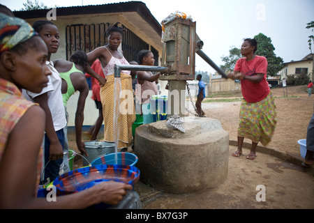 Gli abitanti di un villaggio di pompare acqua da un quartiere ben in Kakata, Libera, Africa occidentale. Foto Stock