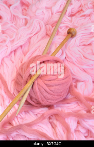 Sfera di lana di colore rosa con aghi Foto Stock