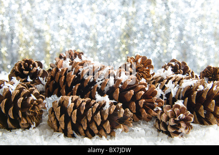 Cono di pino decorazione nella neve con sfondo spumanti Foto Stock