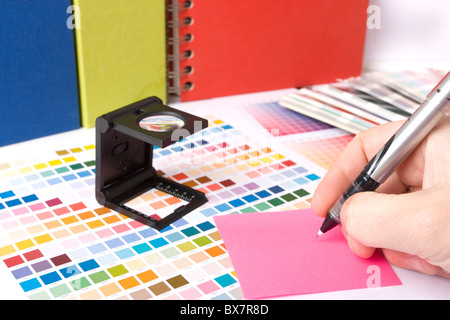 La progettazione grafica e i campioni di colore e le penne su una scrivania Foto Stock
