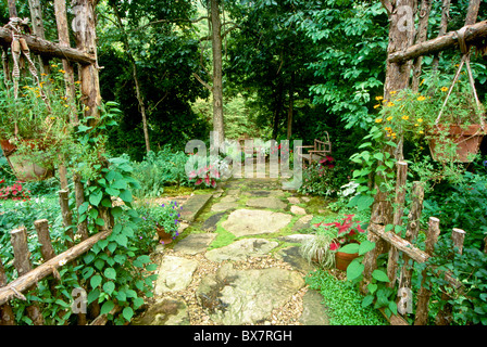 Passeggiate attraverso il cedro fatti a mano archway nell'ombra in giardino per sedersi Foto Stock