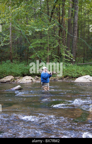 Lone pescatore a mosca sul fiume Oconaluftee vicino Cherokee, North Carolina, STATI UNITI D'AMERICA Foto Stock