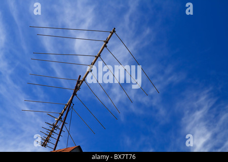 Un tutto-band home antenna UHF e VHF analogica e digitale del segnale di ricezione televisiva sulla parte superiore di una casa residenziale. Foto Stock