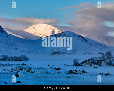Alba di Stob un Choire Odhar oltre a frozen Lochan na h'Achlaise sul bordo di Rannoch Moor nelle Highlands scozzesi Foto Stock