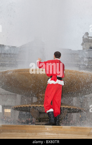 Santacon 2010, flashmob raduno di persone vestite come Santa nel centro di Londra. Santa in Trafalgar Square fontana. Foto Stock