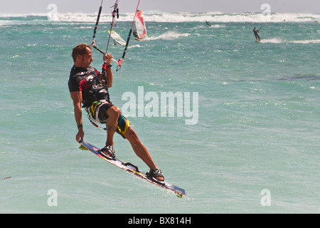 Kite Surfer a metà in aria tenendo la scheda fuori Le Morne, Mauritius Foto Stock