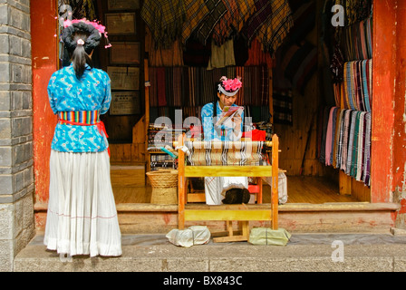 Mosuo donne al negozio di tessuti, Lijiang, Yunnan, Cina Foto Stock