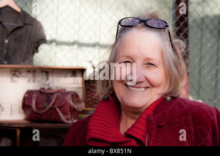 Una donna stallholder si compiace dell'attenzione la sua pressione di stallo sta ricevendo dal fotografo Foto Stock