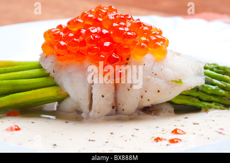 Asparagi con pesce e caviale rosso in salsa cremosa Foto Stock