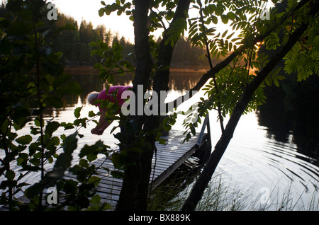 Anziana donna finlandese al molo di sera, Finlandia Foto Stock