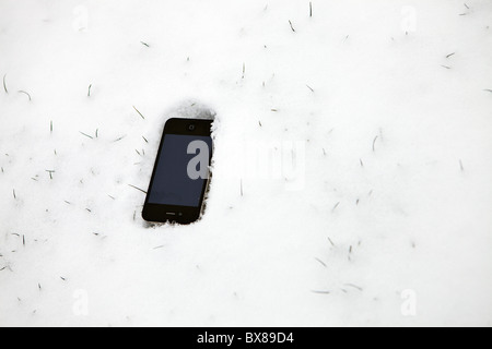 Apple Iphone posa sulla terra nella neve. Foto Stock