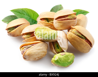 Pistacchi con foglie su sfondo bianco Foto Stock