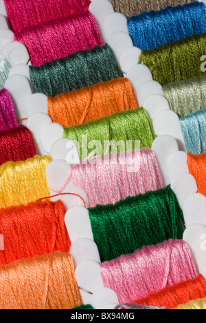 Una selezione delle colorate fili di cotone su bobine Foto Stock