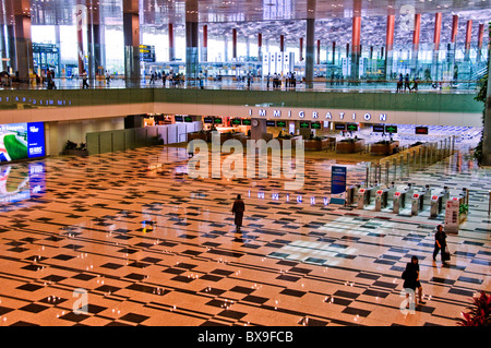 Persone che camminano in vetro lobby ad atrio interno del nuovo e moderno aeroporto Changi di terminale in Singapore Asia del sud-est Foto Stock