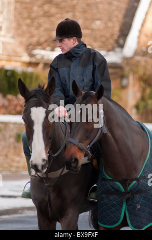 Un pilota locale con due cavalli nel villaggio Costwold di Broadway in Worcestershire, Inghilterra. Foto Stock