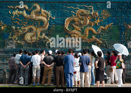 Ai turisti di ammirare le opere d'arte decorativa dei draghi su nove Dragon schermo in Datong, Shanxi, Cina. Foto Stock