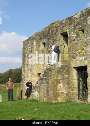 Un gruppo guardando black middens bastle house, tarset valley, Northumberland, Inghilterra, Regno Unito. Foto Stock