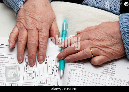 83 enne titolare di pensione o di rendita con puzzle libro e penna England Regno Unito Foto Stock