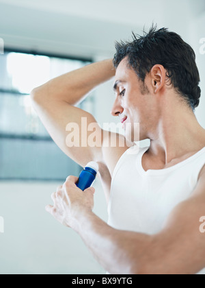 L'uomo applicando deodorante sulle ascelle Foto Stock