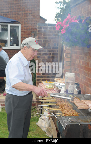 Anziani uomo bianco cuochi sul grande giardino barbecue Foto Stock