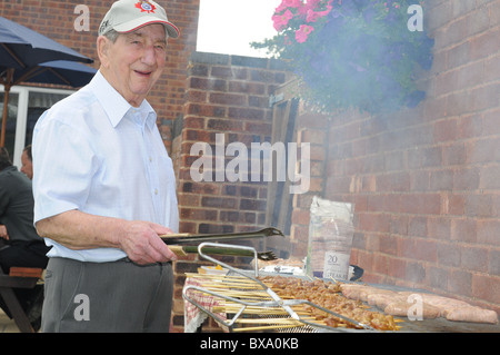 Anziani uomo bianco cuochi sul grande giardino barbecue Foto Stock