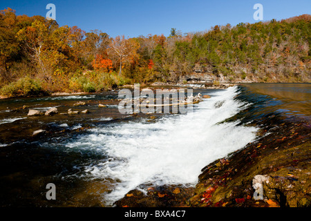 Una cascata lungo un flusso nel Ozarks con la caduta delle foglie il colore nelle zone rurali del Missouri, USA. Foto Stock