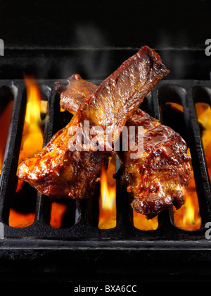 Barbeque costolette di essere cotta su fiamme aperte. Barbecue alimentare foto, foto e immagini. Foto Stock