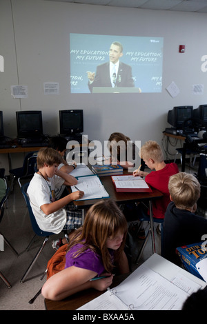 Gli studenti in 6th-grade studi sociali classe prendere appunti mentre si guarda la U.S. Pres. Barack Obama parla di istruzione Foto Stock