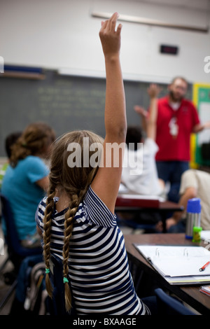 Gli studenti alzare le loro mani per rispondere alla domanda in studi sociali di classe a Kealing Middle School di Austin, Texas Foto Stock