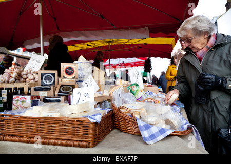 Una donna peruses formaggio su un mercato in stallo, Haslemere, Surrey, Inghilterra. Foto Stock