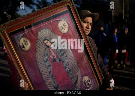 Un pellegrino porta un immagine di Nostra Signora di Guadalupe a Città del Messico Foto Stock