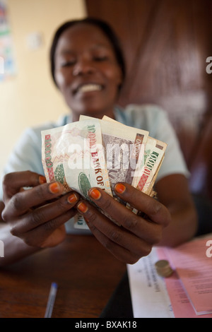 Un ragioniere conta di contanti (scellini ugandesi) in un ufficio a Mbale, Uganda orientale, Africa orientale. Foto Stock