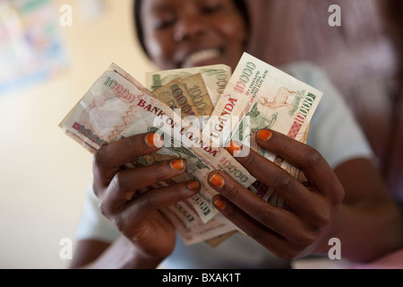 Un ragioniere conta di contanti (scellini ugandesi) in un ufficio a Mbale, Uganda orientale, Africa orientale. Foto Stock