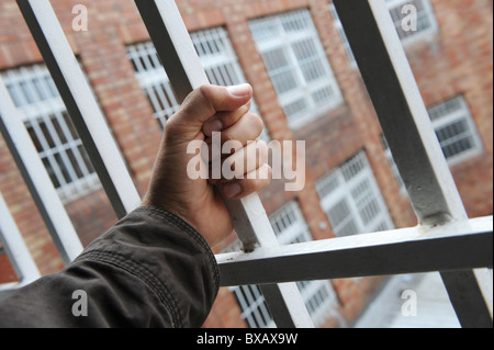 Una mano su barre in un bambino un centro di detenzione Foto Stock