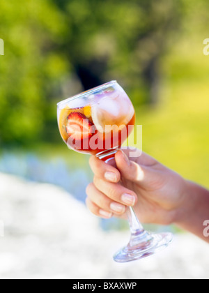 Mano umana tenendo un bicchiere di bibita Foto Stock