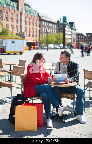 Coppia con mappa a outdoor cafe in città Foto Stock