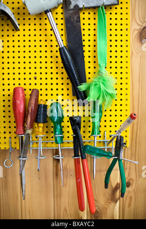 Varietà di worktools appeso sul bordo attaccata al pannello di legno Foto Stock