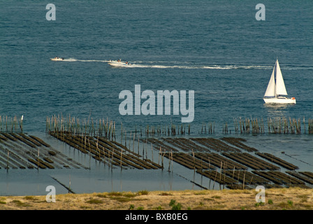 Barche a vela passato un oyster farm in Archachon Bay, Gironde, Francia. Foto Stock