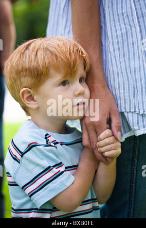 Ragazzo azienda madre mano e guardando lontano Foto Stock