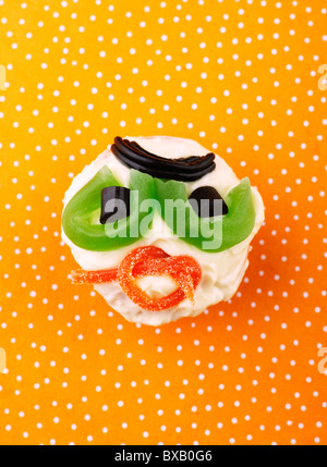 La torta con la faccina sorridente su sfondo maculato Foto Stock