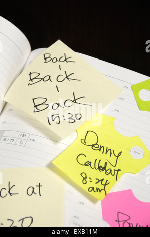 Note adesive bloccati su un diario Foto Stock