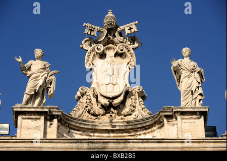 Italia, Roma, Piazza San Pietro, colonnato, statue e stemma Foto Stock