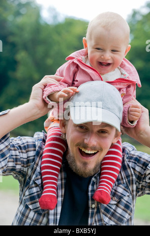 Padre bambino portando sulla spalla, ridendo Foto Stock