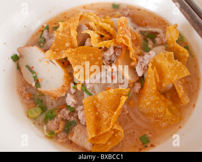 Il piccolo bianco zuppa di noodle con carne macinata di maiale, salsicce di pesce e crisy immotivata foglio. Foto Stock