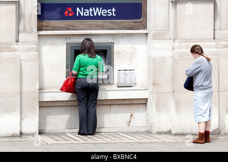 Donna al bancomat della NatWest Bank in London, England, Regno Unito, Europa Foto Stock